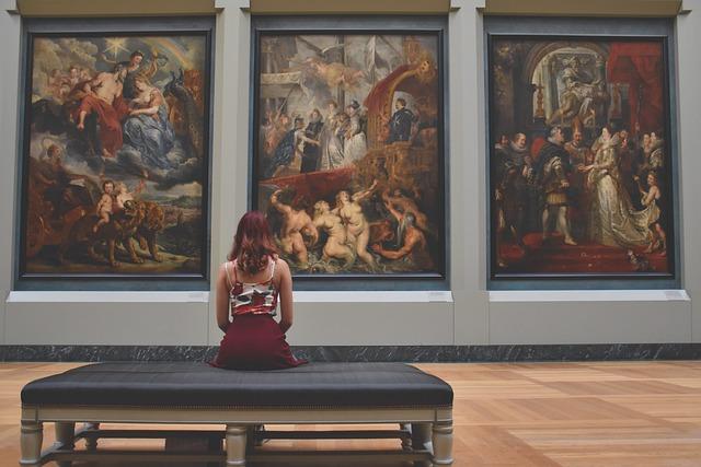 woman sitting in front of art work
